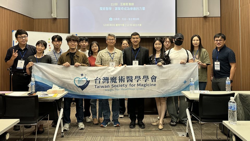 台灣魔術醫學學會成立大會全體與會者在會議室合影，前排手持學會布條