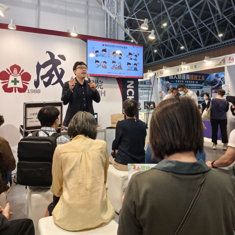 江哲杭諮商心理師站在投影幕前演講，螢幕顯示「魔術諮商的特色與優勢」插圖，聽眾坐在前方